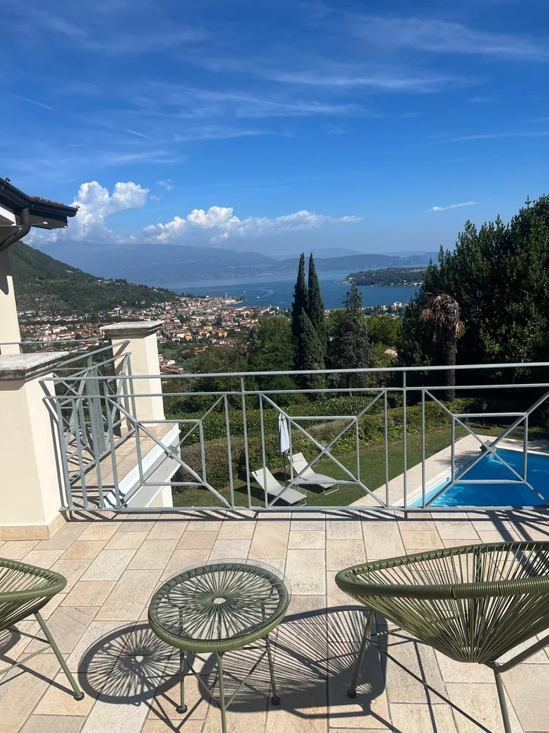 Chaises vertes et petite table sur la terrasse surplombant le golfe de Salò