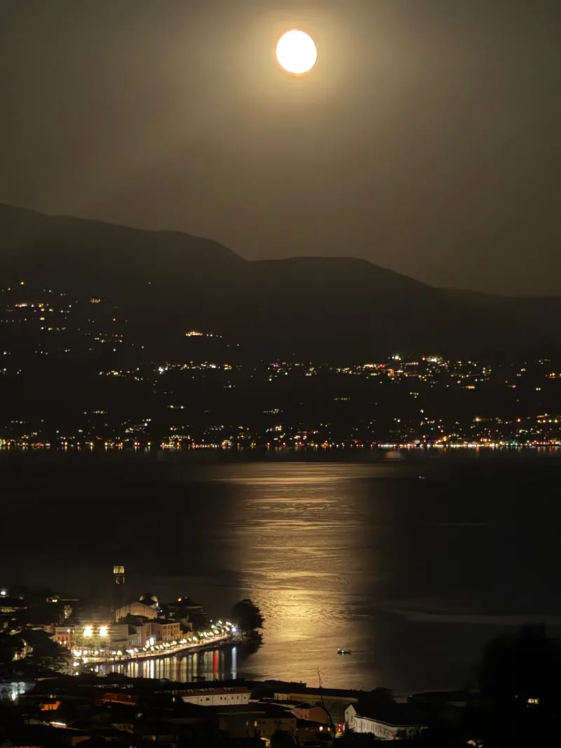 Lune au-dessus du lac de Garde et lumières nocturnes du bord de lac de Salò