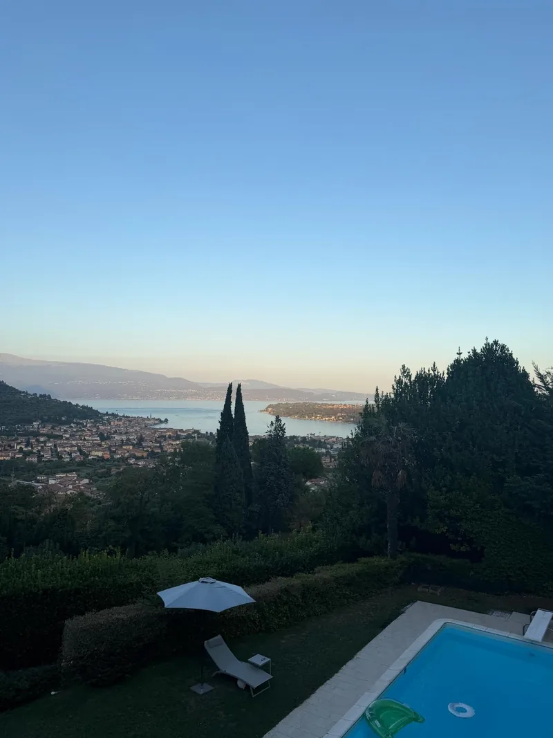 Pool and garden at dusk with the Bay of Salò in the background