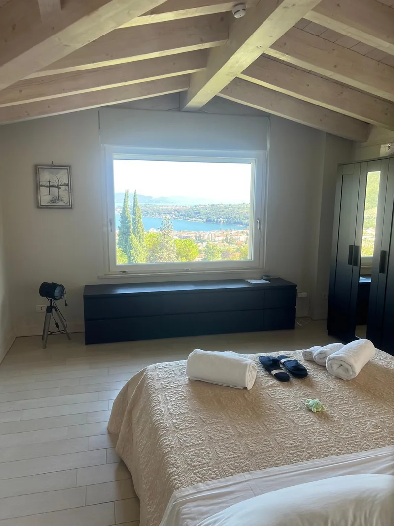 Double bedroom with a beamed ceiling and a large lake-facing window